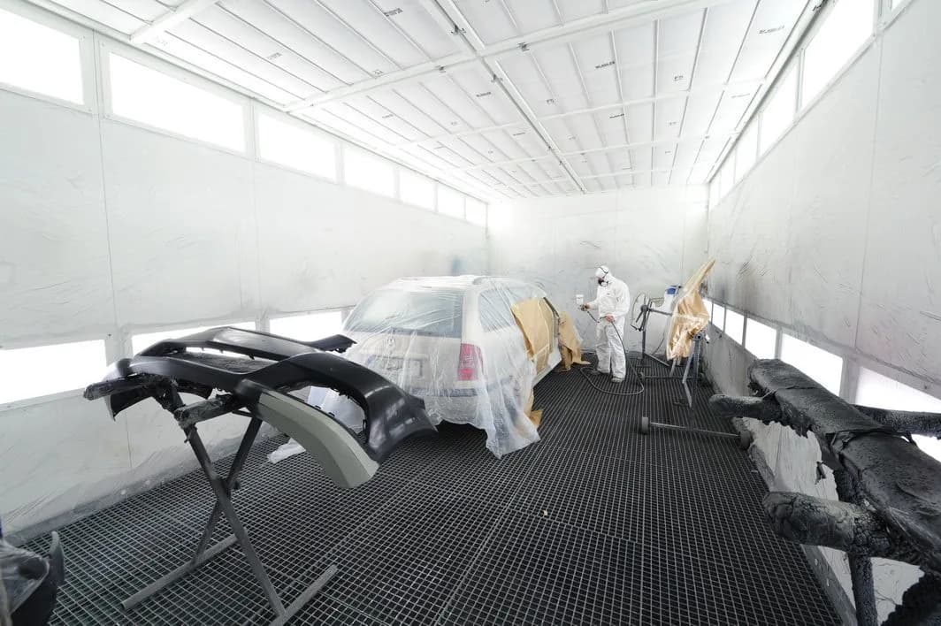 Preparing a car for painting in a workshop booth