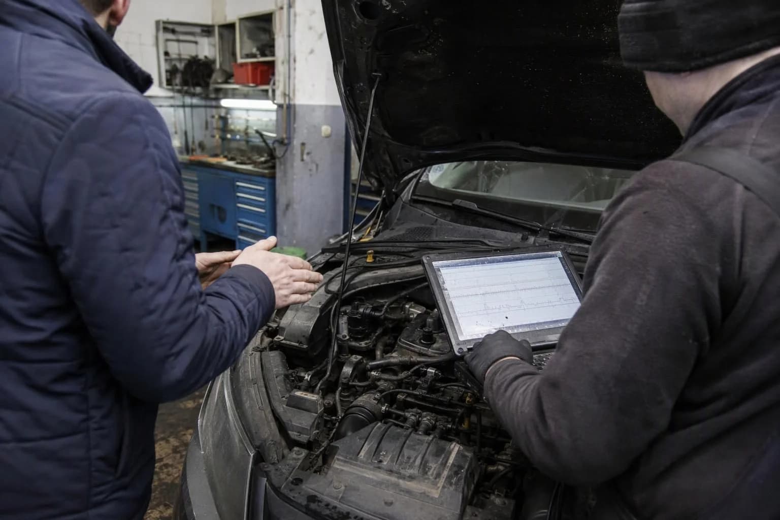 A driver reports engine vibration at idle while a mechanic observes the engine running and reads diagnostic data.